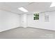 Finished basement with gray carpeting, white walls, and a window for natural light at 9833 White Cascade Dr, Charlotte, NC 28269