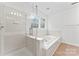 Bright bathroom featuring a glass door shower, soaking tub, and light wood-look floors at 9833 White Cascade Dr, Charlotte, NC 28269