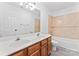 Well-lit bathroom featuring a double sink vanity and a bathtub with tile surround at 9833 White Cascade Dr, Charlotte, NC 28269