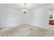 Empty dining room with carpet, chair rail, and chandelier at 9833 White Cascade Dr, Charlotte, NC 28269