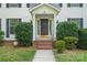 Charming front entrance with black door, white pillars, brick steps, and manicured shrubs at 9833 White Cascade Dr, Charlotte, NC 28269