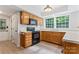 Well-lit kitchen featuring light wood cabinetry, black appliances, and a large window at 9833 White Cascade Dr, Charlotte, NC 28269