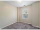 Bedroom with plush carpet, window with blinds, and neutral colored walls at 10094 Treeside Ln, Matthews, NC 28105