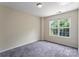 Bedroom with plush carpet, natural light from window, and neutral colored walls at 10094 Treeside Ln, Matthews, NC 28105