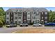 Townhome complex with brick and siding, surrounded by parking, trees and landscaping at 10094 Treeside Ln, Matthews, NC 28105