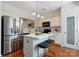 Modern kitchen boasts stainless steel appliances, a center island with seating, and bright white cabinetry at 10094 Treeside Ln, Matthews, NC 28105
