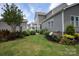Private backyard with manicured lawn, lush landscaping, and a white pergola at 10818 Alvarado Way, Charlotte, NC 28277