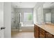 Bathroom with a glass door shower, a soaking tub under a glass block window, and a wooden vanity at 10818 Alvarado Way, Charlotte, NC 28277