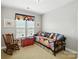 Guest bedroom with a colorful daybed, wood rocking chair, and natural light at 10818 Alvarado Way, Charlotte, NC 28277