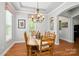 Dining area showcasing wooden table, chairs, and chandelier beneath a tray ceiling at 10818 Alvarado Way, Charlotte, NC 28277