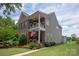 Two-story home features a brick and siding exterior, double porch, American flag, and manicured lawn at 10818 Alvarado Way, Charlotte, NC 28277