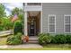 Charming front entrance features a wreath, flower pots, and mature landscaping at 10818 Alvarado Way, Charlotte, NC 28277
