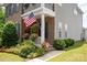Inviting front porch with American flag, hanging flower baskets, and colorful landscaping at 10818 Alvarado Way, Charlotte, NC 28277