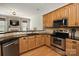Modern kitchen featuring stainless steel appliances, granite countertops, and wooden cabinetry at 10818 Alvarado Way, Charlotte, NC 28277