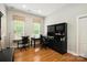Bright office space features natural light, a functional desk setup, and wood flooring at 10818 Alvarado Way, Charlotte, NC 28277