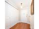 Hallway with wood floors, coat closet and detailed light fixture by front door at 1300 Reece Rd # 402, Charlotte, NC 28209