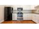 Updated kitchen features white cabinets, stainless steel appliances, and wood floors at 1300 Reece Rd # 402, Charlotte, NC 28209