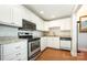 Updated kitchen features white cabinets, stainless steel appliances, and wood floors at 1300 Reece Rd # 402, Charlotte, NC 28209