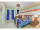 A colorful bedroom offers a twin bed, cheerful wall art, a ceiling fan, and a window with blue curtains at 133 Glade Valley Ave, Mooresville, NC 28117