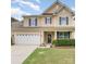 Traditional two-story home boasts a manicured lawn, a two-car garage, and inviting front porch with stylish curb appeal at 133 Glade Valley Ave, Mooresville, NC 28117