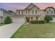 Charming two-story home with a well-maintained lawn, a two-car garage, and an inviting covered front porch at 133 Glade Valley Ave, Mooresville, NC 28117