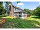 Rear exterior view featuring the screened porch, chimney, and well maintained lawn at 1581 Bluff Ct, Rock Hill, SC 29732