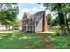 Rear exterior view showing the brick, gray siding, screened porch, and surrounding green lawn at 1581 Bluff Ct, Rock Hill, SC 29732