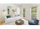 Bright living room with a white sofa, modern artwork, and natural light streaming through the windows at 1581 Bluff Ct, Rock Hill, SC 29732