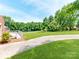 Large grass backyard features mature trees and a walkway leading to the home at 1606 N Rhyne St, Gastonia, NC 28054