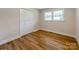 Bright bedroom with wood floors, white trim, closet, and double windows providing natural light at 1606 N Rhyne St, Gastonia, NC 28054