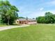Charming single-story home with a brick facade, a spacious lawn, and a long driveway at 1606 N Rhyne St, Gastonia, NC 28054