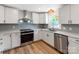 A kitchen with white cabinets, stainless steel appliances, and a window for natural light at 1606 N Rhyne St, Gastonia, NC 28054