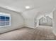 Large bedroom featuring neutral carpet, vaulted ceiling, and windows on two walls at 16815 Spruell St, Huntersville, NC 28078