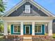 Charming home featuring a beautiful blue exterior with a cozy front porch and white columns at 16815 Spruell St, Huntersville, NC 28078