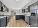 An open-concept kitchen featuring stainless steel appliances, granite countertops, and hardwood floors at 16815 Spruell St, Huntersville, NC 28078