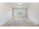 Bright bedroom with three windows showcasing natural light and neighborhood views at 172 Briana Marie Way, Indian Trail, NC 28079