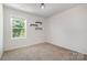 Bedroom with decorative shelves, a large window overlooking trees, and neutral carpet at 172 Briana Marie Way, Indian Trail, NC 28079