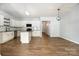 Open kitchen and living area with modern light fixtures, wood-look floors, and white cabinets at 172 Briana Marie Way, Indian Trail, NC 28079