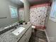 Bright bathroom with a white vanity, granite countertop, and decorative shower curtain at 1723 Lowder St, Albemarle, NC 28001