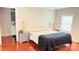 Warm bedroom featuring hardwood floors, cozy bed with lamps, and a glimpse into an en-suite bathroom at 210 W Church St, Cherryville, NC 28021