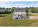 Exterior of home features a two-story deck, lawn, and mature trees under a sunny blue sky at 2268 Bay Ct, Newton, NC 28658