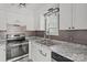 Modern kitchen features white cabinetry, granite countertops, stainless steel appliances, and stylish backsplash at 2268 Bay Ct, Newton, NC 28658
