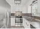 Modern kitchen features white cabinetry, granite countertops, stainless steel appliances, and stylish backsplash at 2268 Bay Ct, Newton, NC 28658