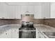 Modern kitchen features white cabinetry, granite countertops, stainless steel appliances, and stylish backsplash at 2268 Bay Ct, Newton, NC 28658