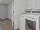 Bright laundry room showcasing a white washer and dryer set with closet and cabinet storage at 2268 Bay Ct, Newton, NC 28658