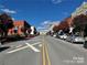 Scenic street view featuring a variety of buildings, street parking, and lush trees against a clear blue sky at 250 Nixon Rd # 41, Belmont, NC 28012
