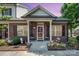 Charming brick home featuring a covered front entrance, beautiful landscaping, and outdoor seating area at 2773 Clover Nw Rd, Concord, NC 28027
