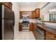Kitchen showcasing stainless steel appliances, dark wood cabinets, and tile flooring at 2773 Clover Nw Rd, Concord, NC 28027