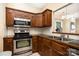 Well-equipped kitchen features stainless steel appliances, dark wood cabinets, and tile backsplash at 2773 Clover Nw Rd, Concord, NC 28027