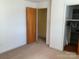 This bedroom has neutral carpet and paint, a closet and a door leading to another room at 3009 Grier St, Newton, NC 28658